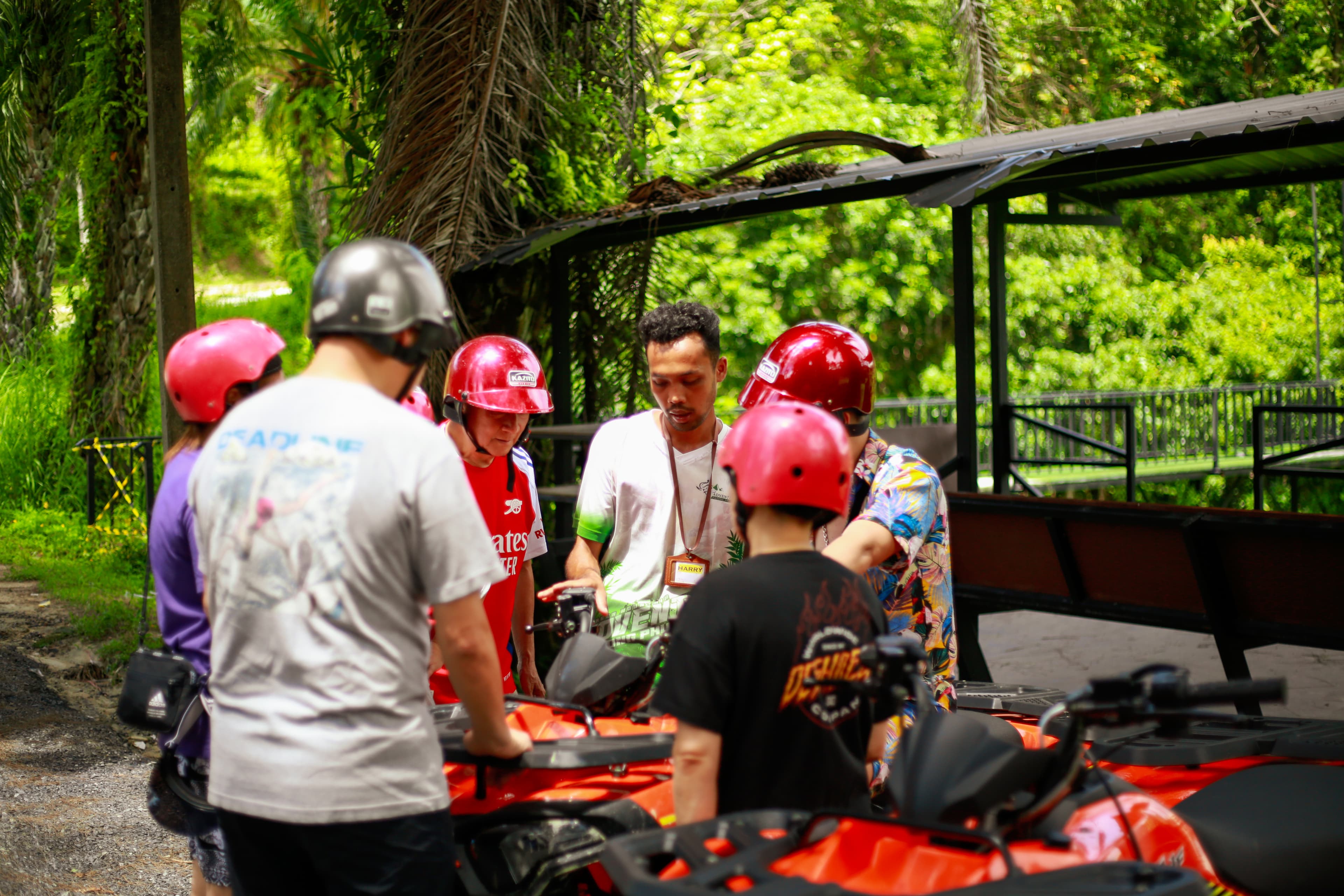 Guide conducting a safety briefing with guests in red helmets