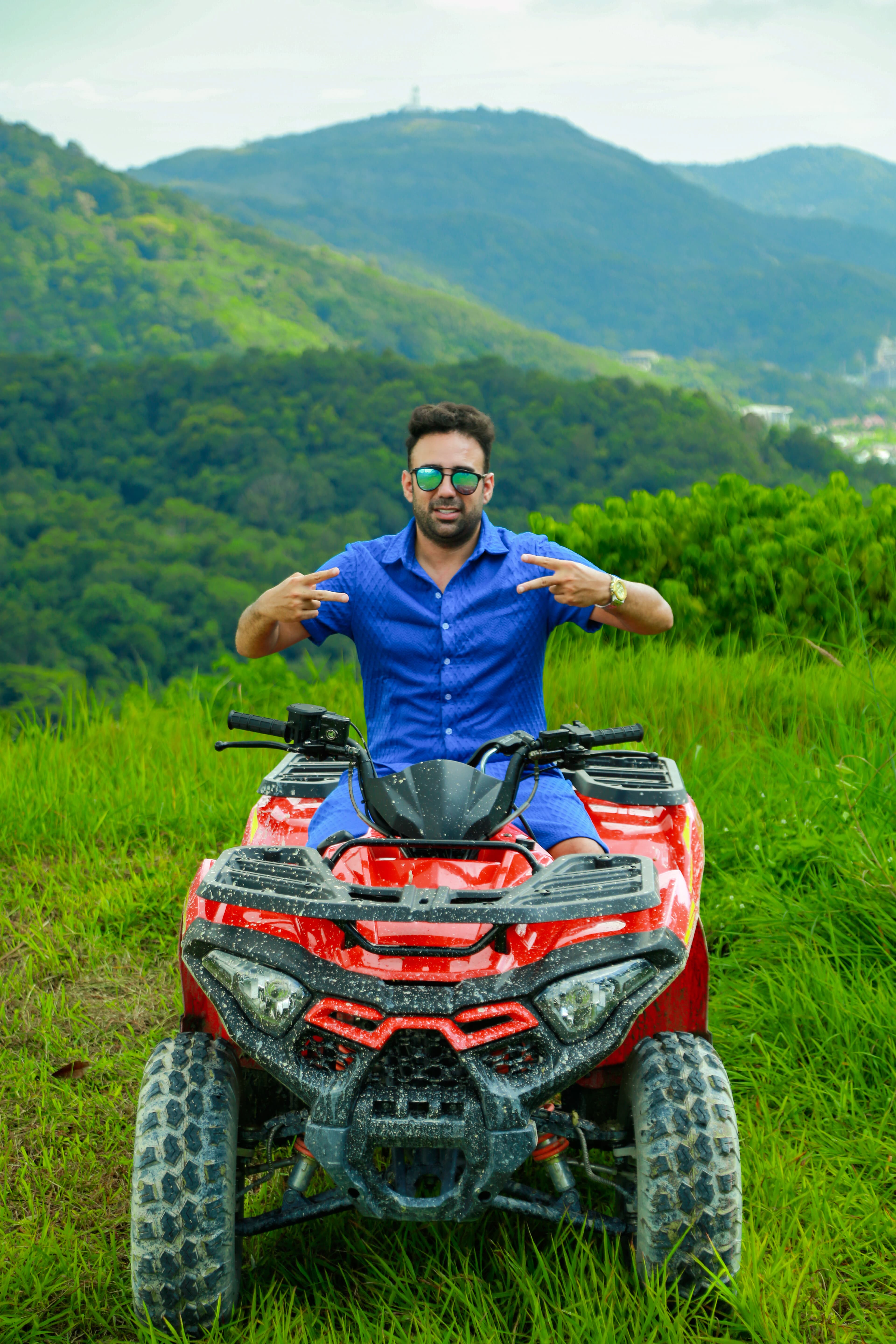 Rider on a red ATV with mountains in the background